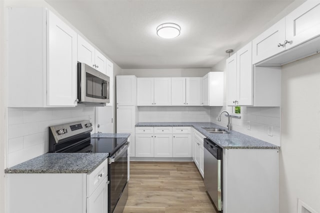 kitchen with stainless steel appliances, a sink, and white cabinets