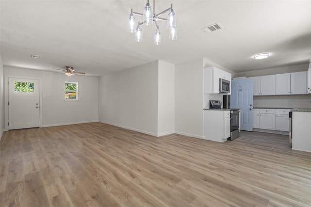 unfurnished living room featuring light wood-style floors, baseboards, a ceiling fan, and a chandelier