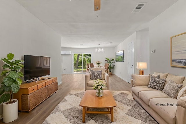 living area featuring a chandelier, wood finished floors, and baseboards