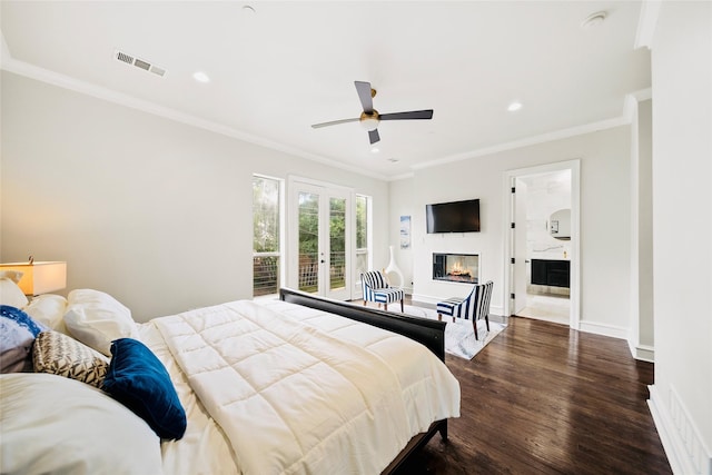 bedroom with dark wood-style floors, recessed lighting, a glass covered fireplace, crown molding, and baseboards