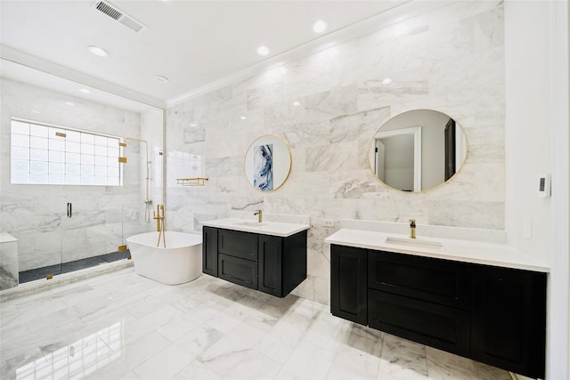 bathroom featuring tile walls, a shower stall, two vanities, marble finish flooring, and a freestanding tub