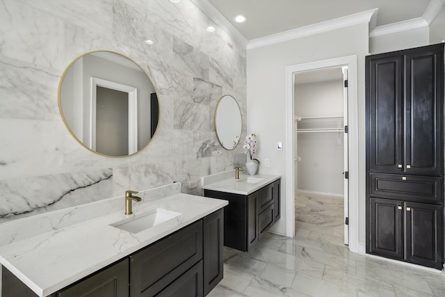full bath featuring crown molding, marble finish flooring, two vanities, recessed lighting, and tile walls