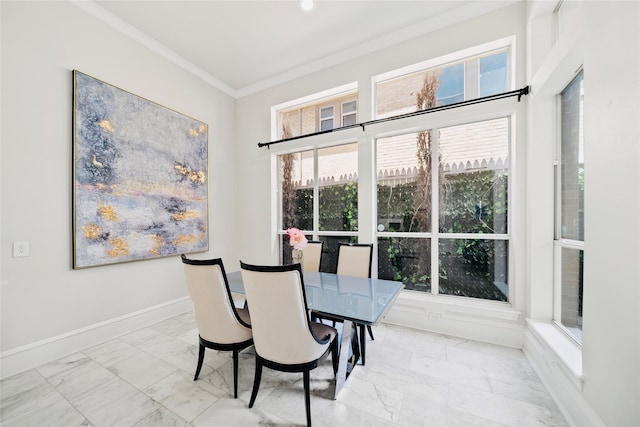 dining room with marble look tiles, plenty of natural light, ornamental molding, and baseboards