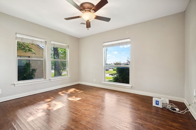spare room with baseboards, wood-type flooring, and a ceiling fan