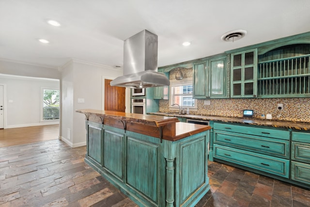 kitchen featuring green cabinets, crown molding, stainless steel oven, backsplash, and recessed lighting