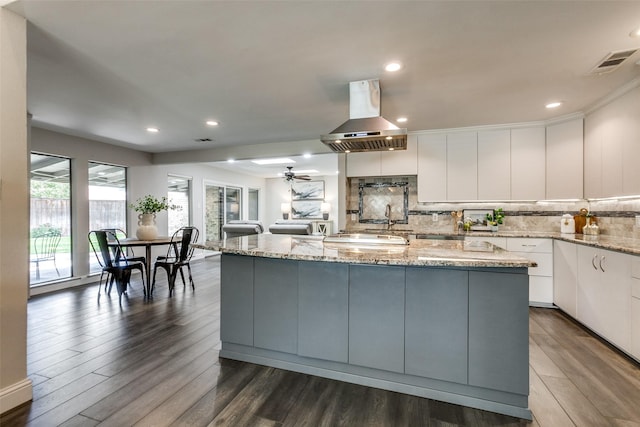 2701 W Prairie Creek Dr, Richardson, TX 75080 - kitchen featuring island exhaust hood, white cabinets, dark wood finished floors, decorative backsplash, and recessed lighting