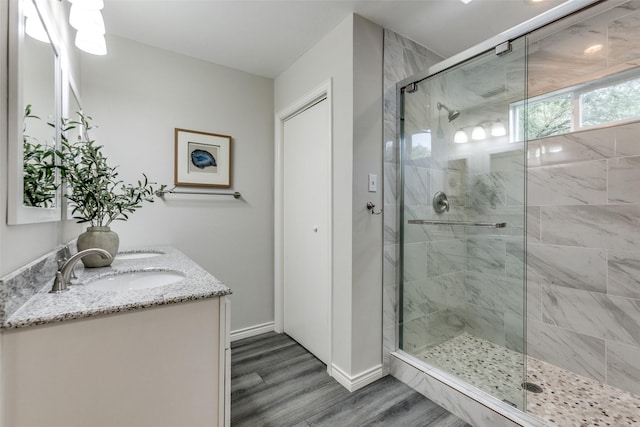2701 W Prairie Creek Dr, Richardson, TX 75080 - bathroom featuring a shower stall, wood finished floors, double vanity, and baseboards