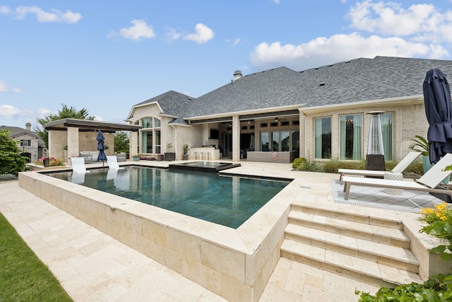 back of house with a patio area, a shingled roof, brick siding, an outdoor hangout area, and a pool with connected hot tub