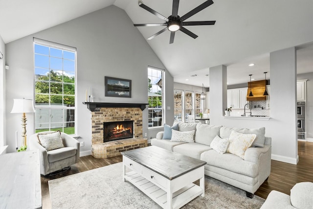 1209 Bel Air Dr, Allen, TX 75013 - living room with ceiling fan, high vaulted ceiling, a brick fireplace, dark wood-style flooring, and recessed lighting