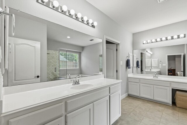 1209 Bel Air Dr, Allen, TX 75013 - full bathroom with a shower stall, two vanities, tile patterned floors, and baseboards