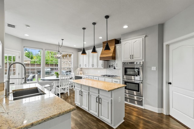 1209 Bel Air Dr, Allen, TX 75013 - kitchen with a sink, a warming drawer, stainless steel appliances, a center island, and premium range hood