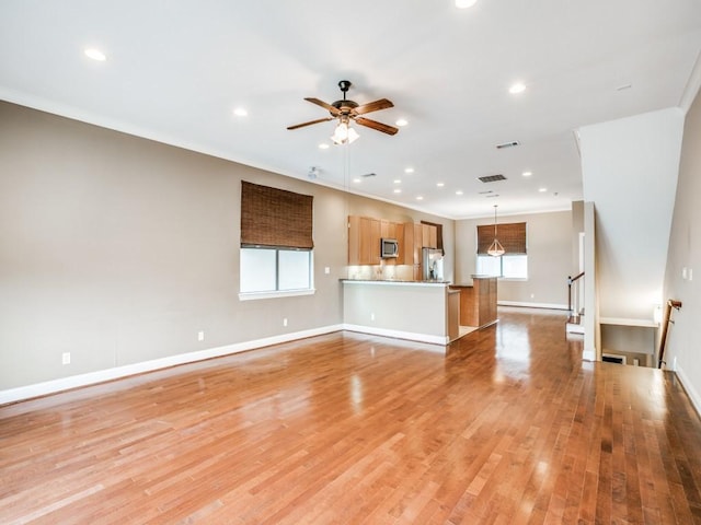 unfurnished living room featuring ceiling fan, recessed lighting, light wood finished floors, baseboards, and crown molding