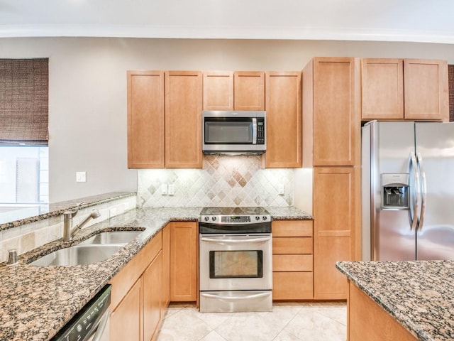 kitchen with appliances with stainless steel finishes, a sink, light stone countertops, tasteful backsplash, and light tile patterned floors