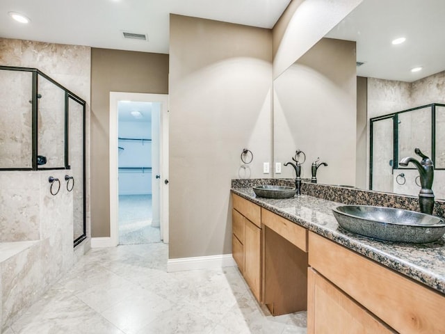 full bathroom featuring a stall shower, a walk in closet, double vanity, recessed lighting, and marble finish flooring