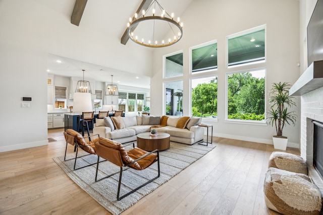 4141 Splitrock Dr, Prosper, TX 75078 - living room featuring high vaulted ceiling, a chandelier, a fireplace, baseboards, and light wood-style flooring