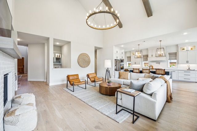 4141 Splitrock Dr, Prosper, TX 75078 - living room featuring light wood-style floors, a fireplace, baseboards, high vaulted ceiling, and a chandelier
