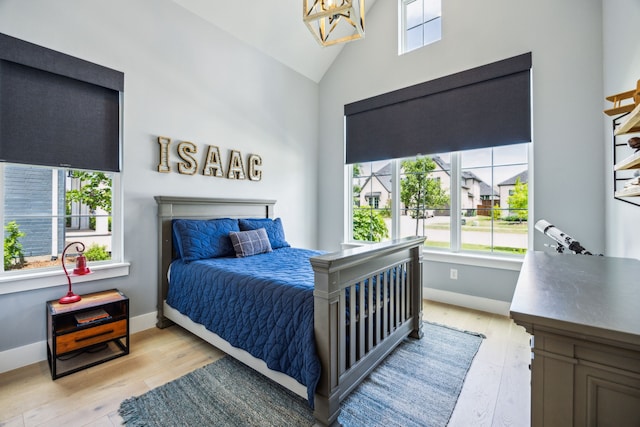 4141 Splitrock Dr, Prosper, TX 75078 - bedroom with light wood-style flooring, baseboards, a chandelier, and high vaulted ceiling