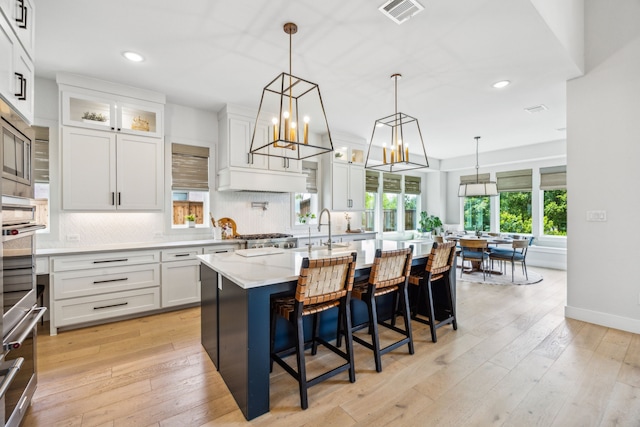 4141 Splitrock Dr, Prosper, TX 75078 - kitchen featuring recessed lighting, backsplash, white cabinetry, light wood-type flooring, and a kitchen island with sink