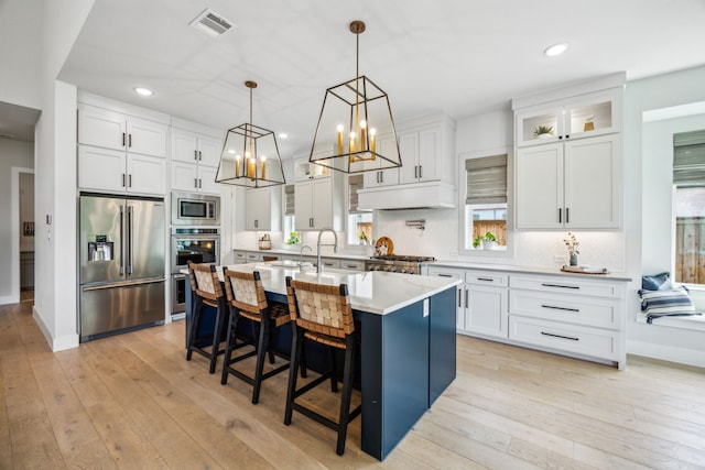 4141 Splitrock Dr, Prosper, TX 75078 - kitchen featuring stainless steel appliances, backsplash, light countertops, a kitchen breakfast bar, and white cabinetry
