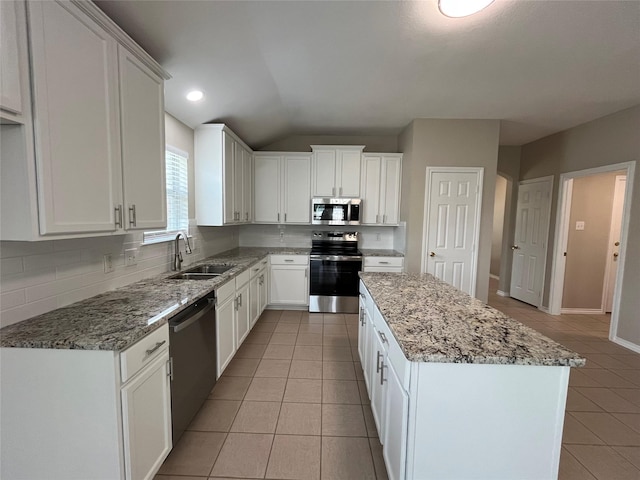 3108 Bryce Dr, Wylie, TX 75098 - kitchen with appliances with stainless steel finishes, light tile patterned floors, tasteful backsplash, a kitchen island, and light stone countertops