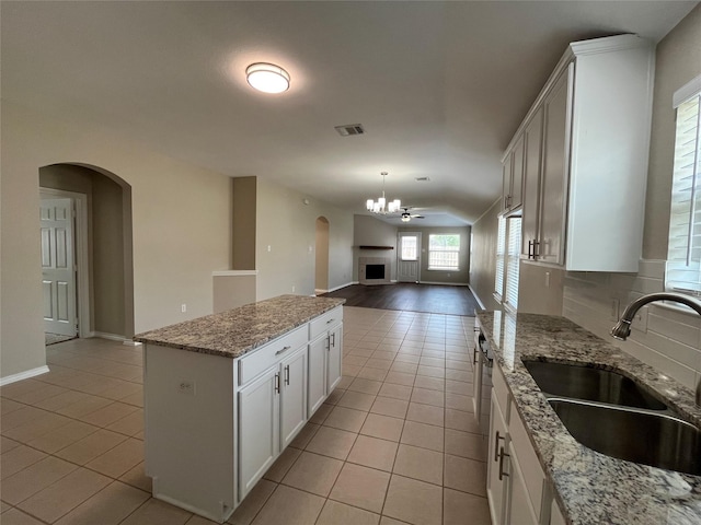 3108 Bryce Dr, Wylie, TX 75098 - kitchen featuring light tile patterned floors, lofted ceiling, arched walkways, a center island, and open floor plan