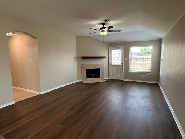 3108 Bryce Dr, Wylie, TX 75098 - unfurnished living room featuring arched walkways, wood finished floors, ceiling fan, and a fireplace