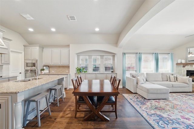 432 Sagebrush Dr, Aledo, TX 76008 - dining space with dark wood-style flooring, plenty of natural light, a stone fireplace, recessed lighting, and vaulted ceiling