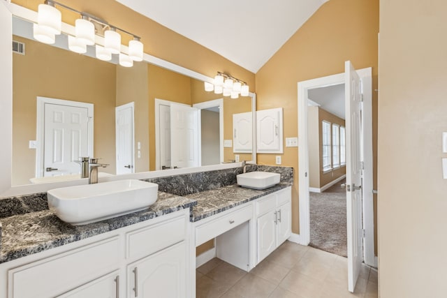 9434 Abbey Rd, Irving, TX 75063 - full bath with double vanity, tile patterned flooring, baseboards, and high vaulted ceiling