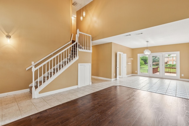9434 Abbey Rd, Irving, TX 75063 - unfurnished living room featuring wood finished floors, stairway, a high ceiling, french doors, and baseboards