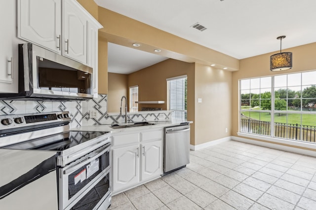9434 Abbey Rd, Irving, TX 75063 - kitchen with appliances with stainless steel finishes, a sink, backsplash, white cabinetry, and baseboards