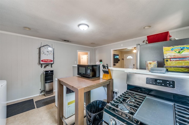 1119 Mccormick St, Denton, TX 76201 - kitchen with gas stove, black microwave, baseboards, crown molding, and a textured ceiling