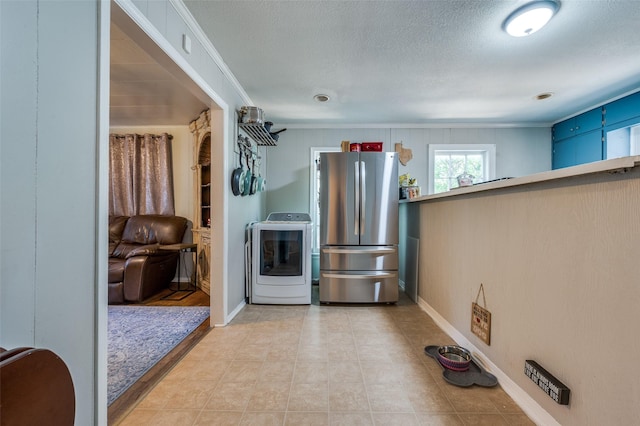 1119 Mccormick St, Denton, TX 76201 - kitchen with washer / clothes dryer, freestanding refrigerator, ornamental molding, a textured ceiling, and baseboards