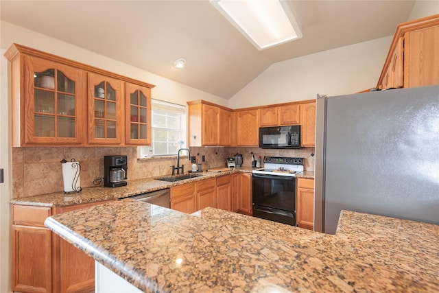 kitchen featuring stainless steel appliances, a sink, tasteful backsplash, lofted ceiling, and glass insert cabinets