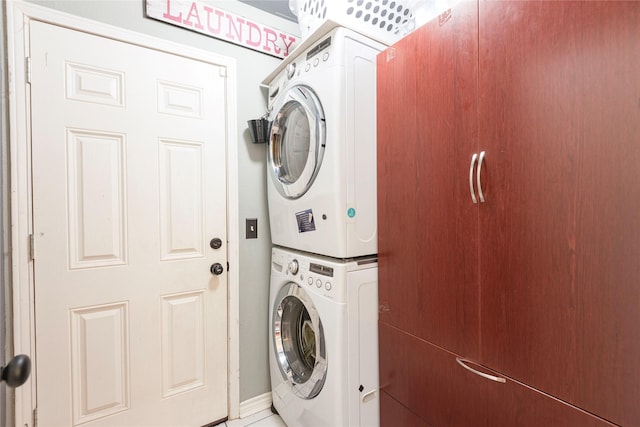 laundry area featuring estacked washer and dryer and baseboards