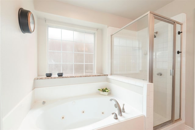bathroom featuring a stall shower and a tub with jets
