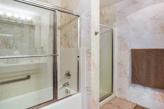 bathroom featuring combined bath / shower with glass door