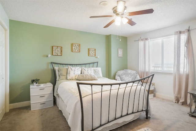 carpeted bedroom featuring a textured ceiling, ceiling fan, and baseboards