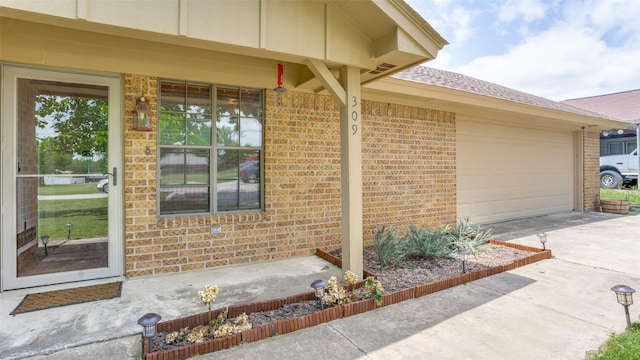 309 W 5th St, Justin, TX 76247 - doorway to property with brick siding, concrete driveway, a garage, and a shingled roof