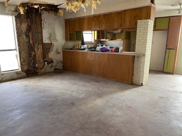 207 County Road 1739, Yantis, TX 75497 - kitchen with concrete floors and brown cabinetry