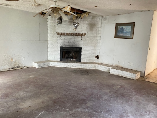 207 County Road 1739, Yantis, TX 75497 - unfurnished living room with concrete flooring, a brick fireplace, ceiling fan, and a textured ceiling