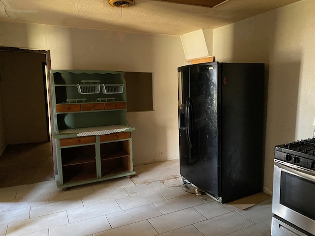 501 S Clay St, Henrietta, TX 76365 - kitchen featuring black fridge and gas stove