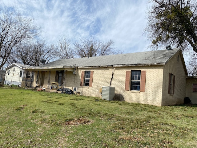 501 S Clay St, Henrietta, TX 76365 - back of property featuring brick siding, cooling unit, and a lawn