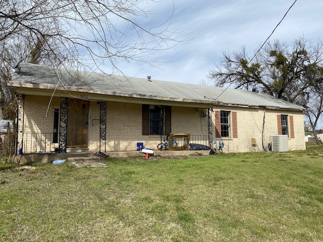 501 S Clay St, Henrietta, TX 76365 - rear view of house with brick siding, central AC unit, a yard, and covered porch