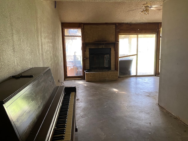 501 S Clay St, Henrietta, TX 76365 - unfurnished living room with concrete floors, a brick fireplace, a ceiling fan, and a textured ceiling