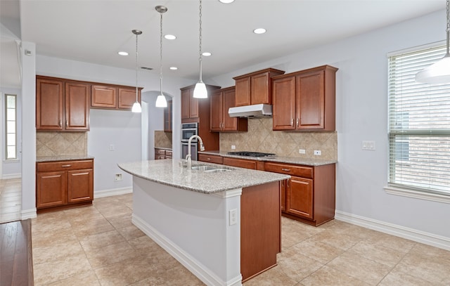 1056 Enchanted Rock Dr, Allen, TX 75013 - kitchen featuring a sink, under cabinet range hood, brown cabinetry, and recessed lighting