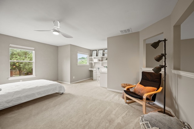 bedroom with multiple windows, light carpet, a ceiling fan, and baseboards