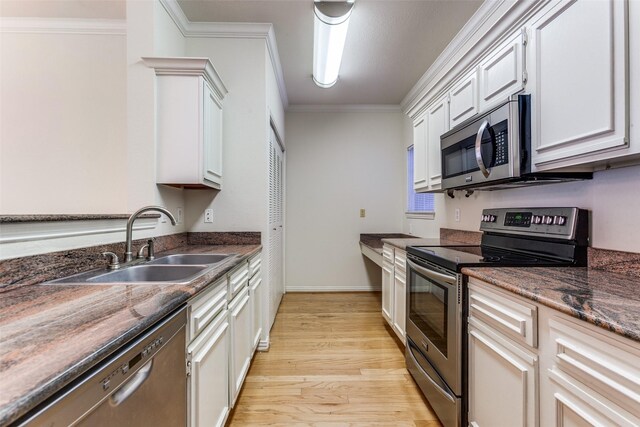 2524 Preston Rd Unit 204, Plano, TX 75093 - kitchen with appliances with stainless steel finishes, a sink, light wood-type flooring, ornamental molding, and white cabinetry