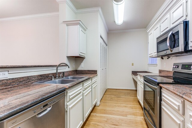 2524 Preston Rd Unit 204, Plano, TX 75093 - kitchen with appliances with stainless steel finishes, a sink, crown molding, light wood finished floors, and baseboards