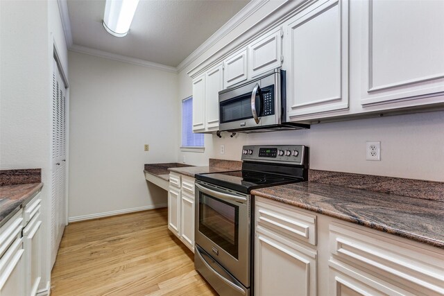 2524 Preston Rd Unit 204, Plano, TX 75093 - kitchen featuring appliances with stainless steel finishes, ornamental molding, light wood-style flooring, white cabinetry, and dark stone counters