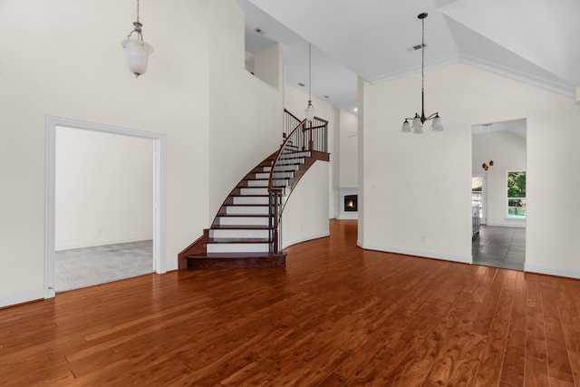 8204 Saint Clair Dr, Mckinney, TX 75071 - unfurnished living room featuring high vaulted ceiling, wood finished floors, a chandelier, stairs, and baseboards